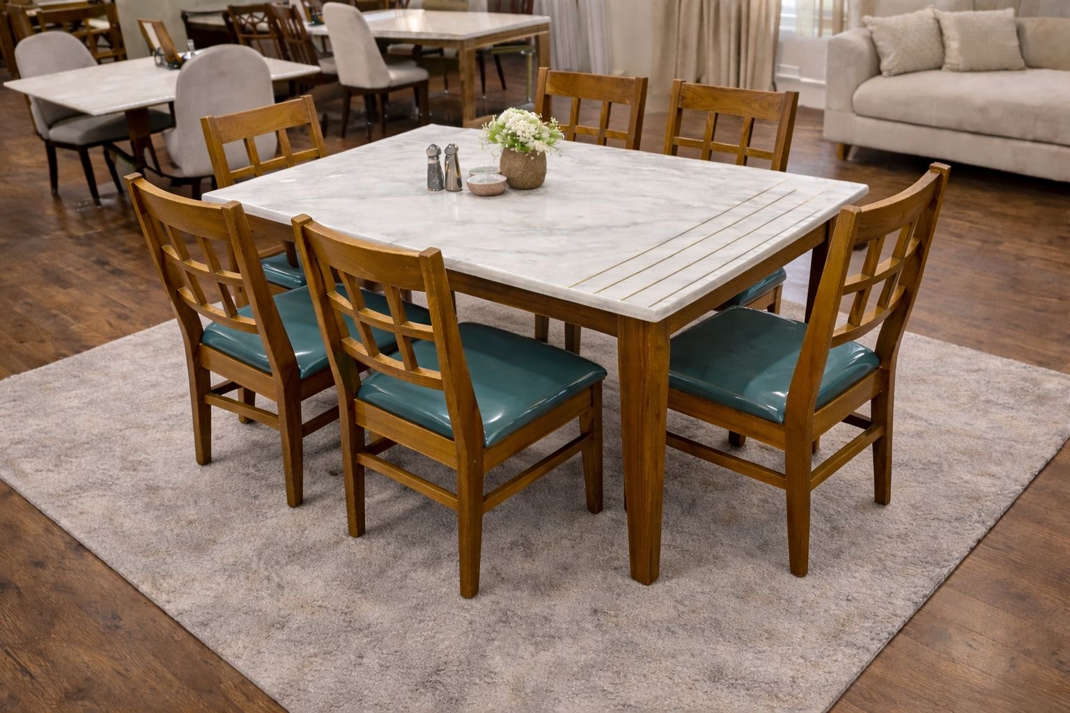 6-seater dining table with wooden chairs that have teal vinyl seat cushions and a white marble top.