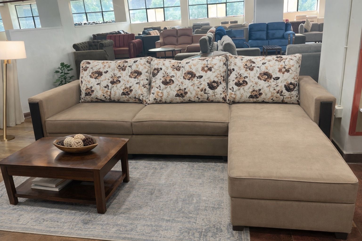 beige fabric L‑shaped sectional sofa with floral accent pillows.